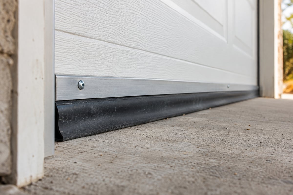 Rubber bottom seal meeting a concrete threshold